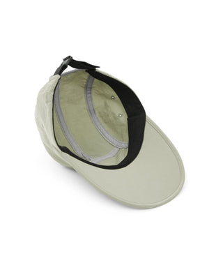 Flat visor cap laid out with other outdoor gear.