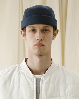 Skull caps in a variety of materials on a stone bench.