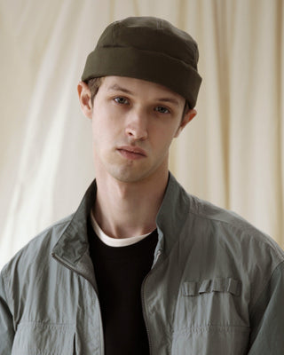 A watch cap with a minimalist design on a wooden dock.