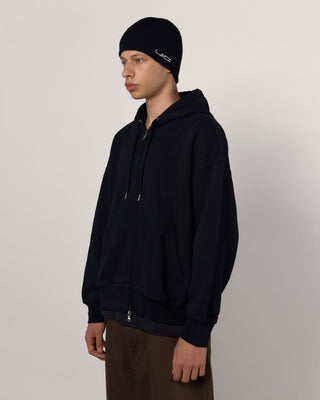 Person wearing a beanie in a snowy landscape