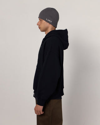 Person wearing a beanie in a snowy landscape