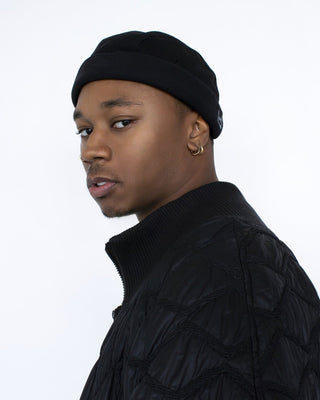 Model wearing a black washed mold cap, a brimless cap from UNDERCONTROL