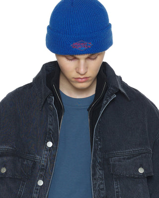 model-wearing-undercontrol-brand-light-blue-color-knit-beanie-with-logo-photo