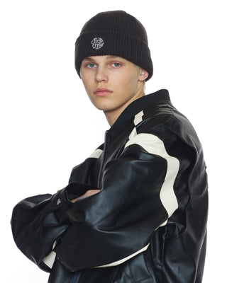 model-wearing-undercontrol-brand-charcoal-black-color-knit-beanie-with-logo-photo