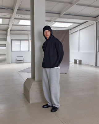 model-wearing-undercontrol-brand-black-color-no-cuff-knit-beanie-with-logo-photo