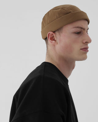 model-wearing-undercontrol-brand-desert-brown-color-brimless-hat-photo