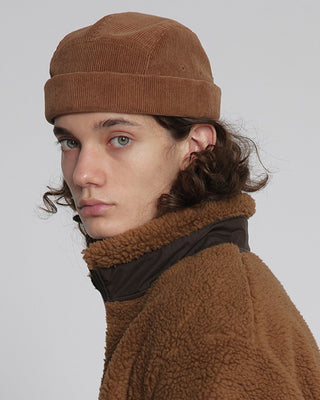 model-wearing-undercontrol-brand-brown-color-corduroy-fabric-brimless-hat-photo