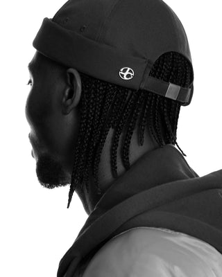 model-wearing-undercontrol-overfit-brimless-cap-black-and-white-photo