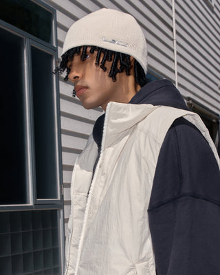 model-side-view-wearing-undercontrol-brand-milk-ivory-color-no-cuff-beanie-photo