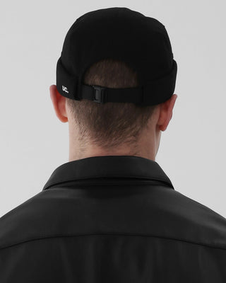 model-back-view-wearing-undercontrol-brand-black-color-brimless-cap-photo